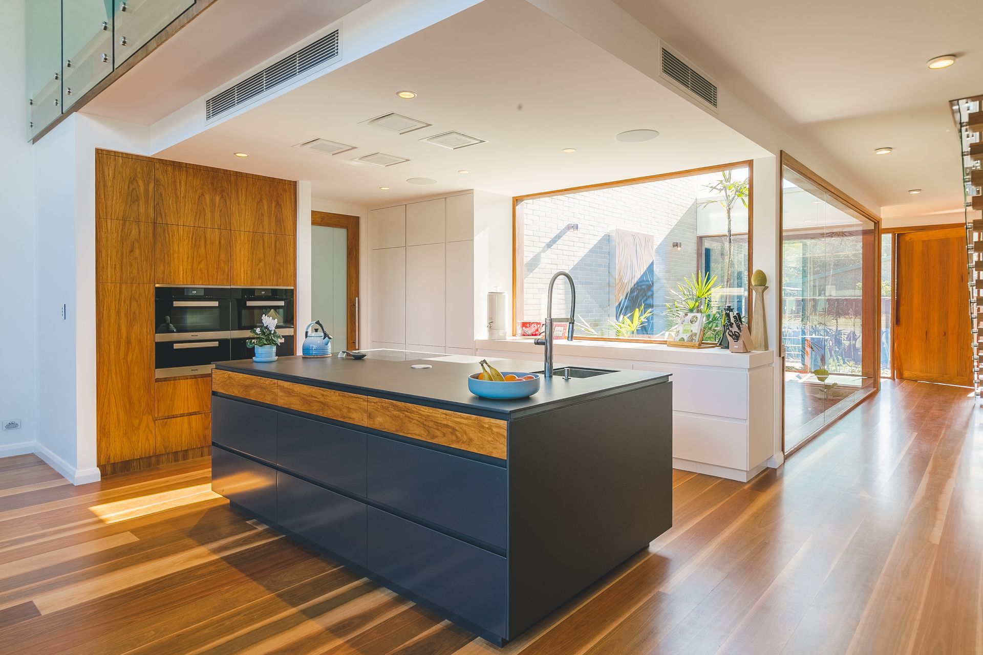 View of a kitchen island with a sink included and two ovens in the background - Concept Kitchens in Port Macquarie NSW