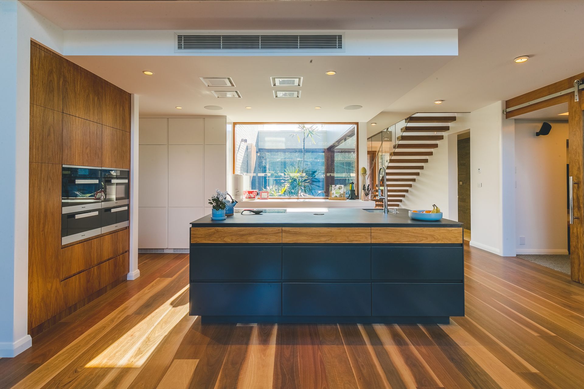 View of a kitchen island with stairs visible in the background- Concept Kitchens in Port Macquarie NSW