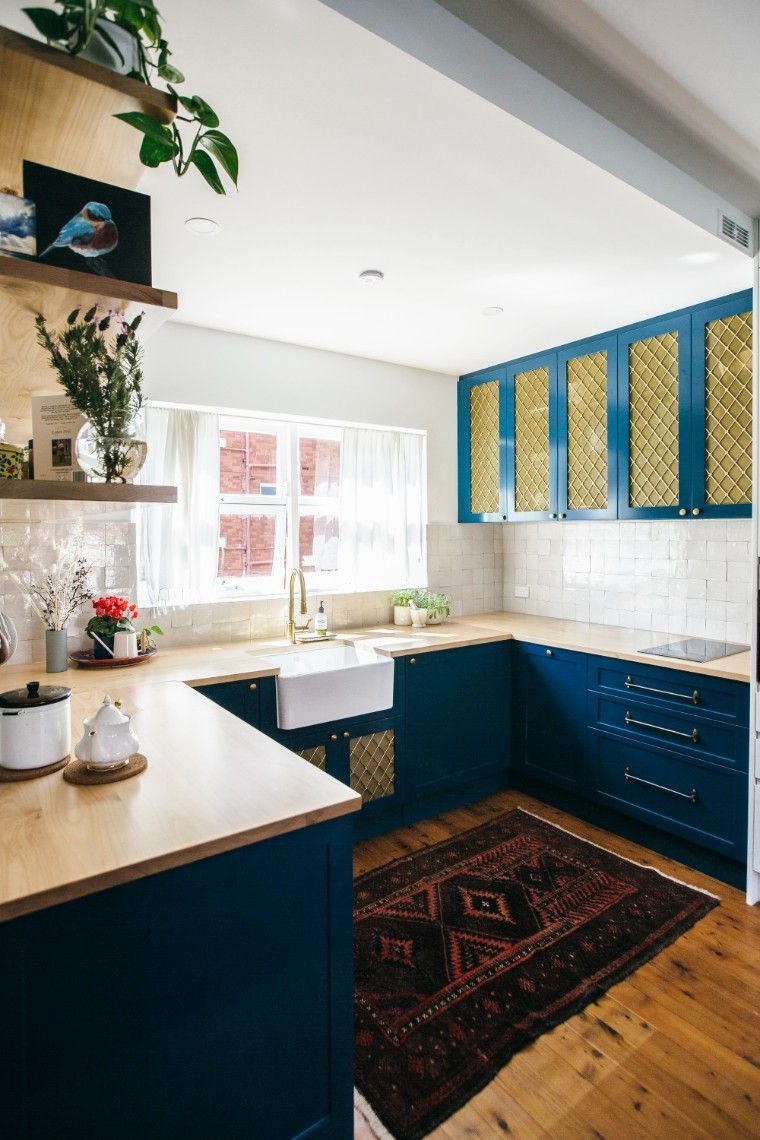 A Kitchen With Blue Cabinets And A Rug On The Floor — Concept Kitchens In Port Macquarie, NSW