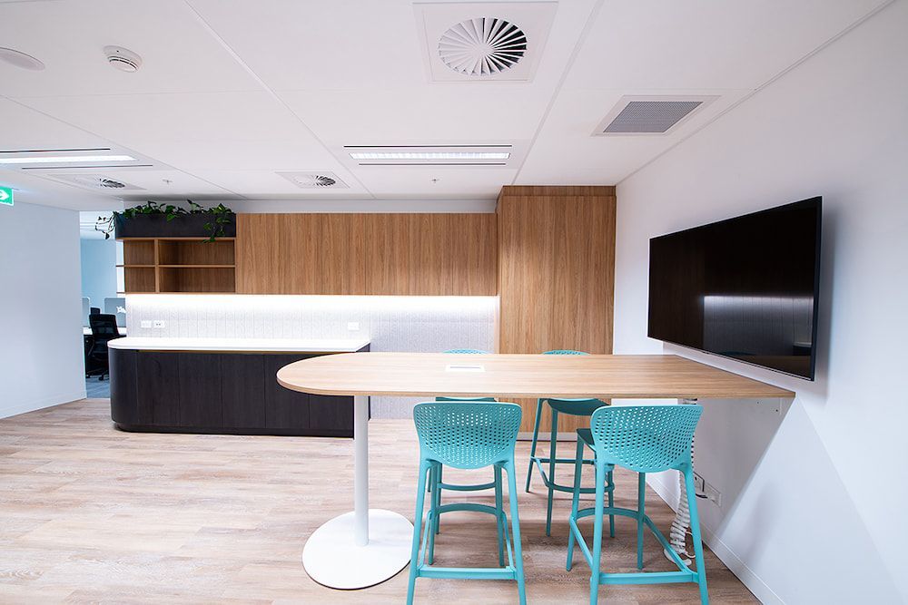 A Room With a Table and Chairs and a Flat Screen TV on the Wall — Concept Kitchens In Port Macquarie, NSW