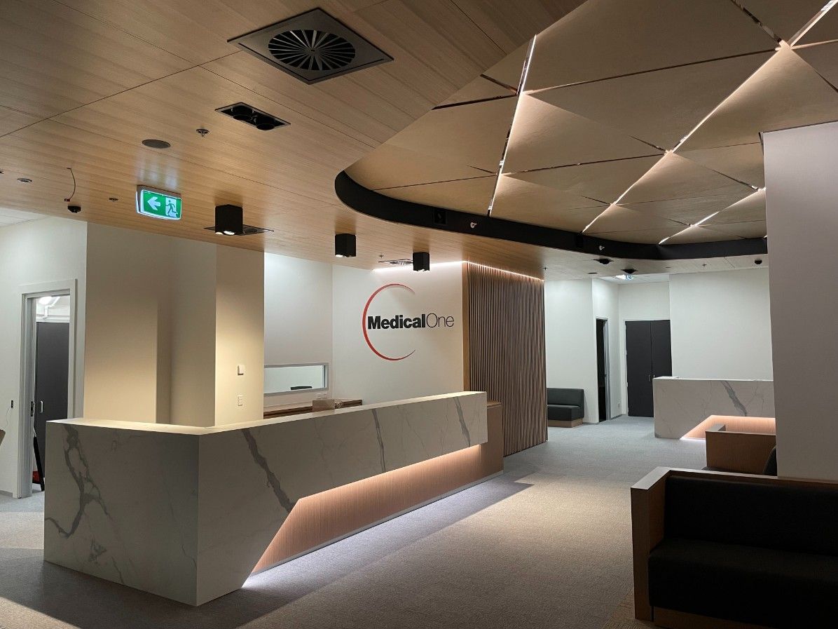 A Well-Lit Reception Area With A Marble Counter And A Brown Wooden Ceiling — Concept Kitchens In Port Macquarie, NSW