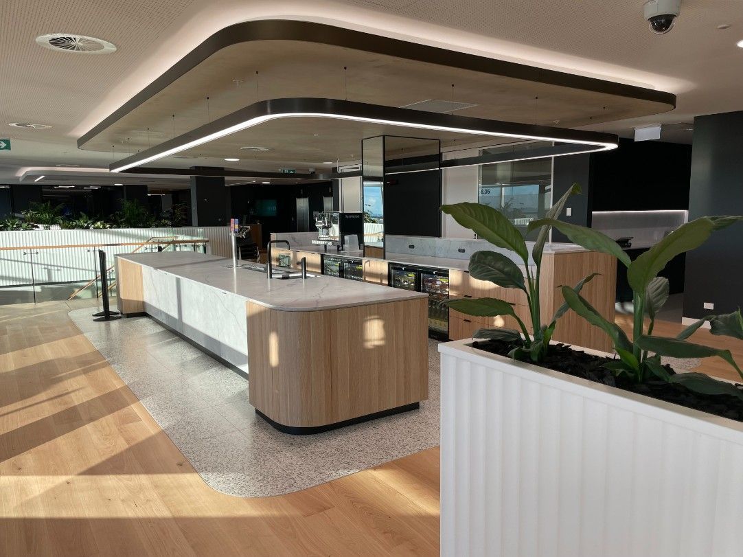 A Large Room With A Wooden Floor And A Counter In The Middle Of It — Concept Kitchens In Port Macquarie, NSW