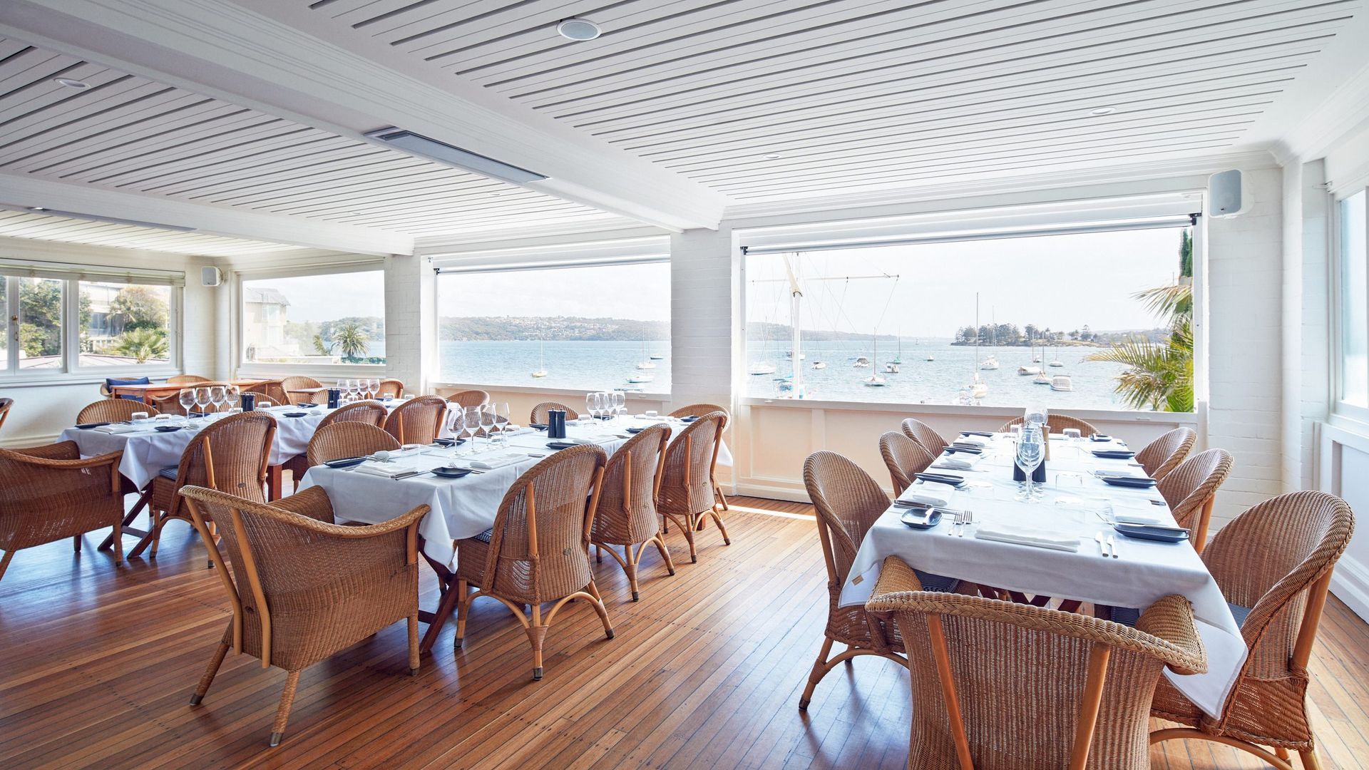 A Bright, Airy Dining Room With Wicker Chairs And White Linen-covered Tables — Concept Kitchens In Port Macquarie, NSW