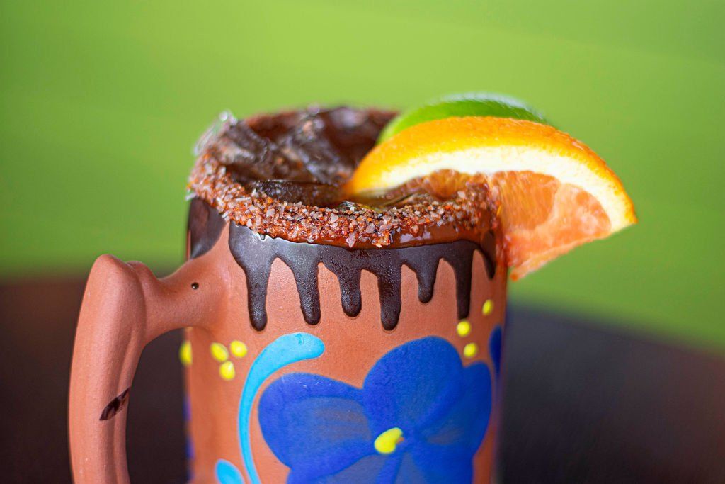 A mug with a slice of orange on top of it.