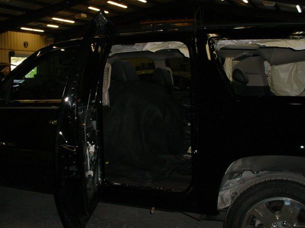 Black SUV with open door, visible interior damage, likely after an accident.