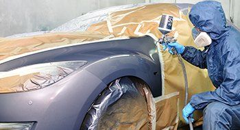 Worker painting car