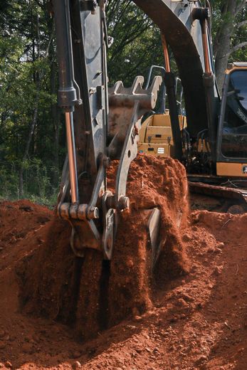 Yellow and black tracked skid steer loader on a construction site.