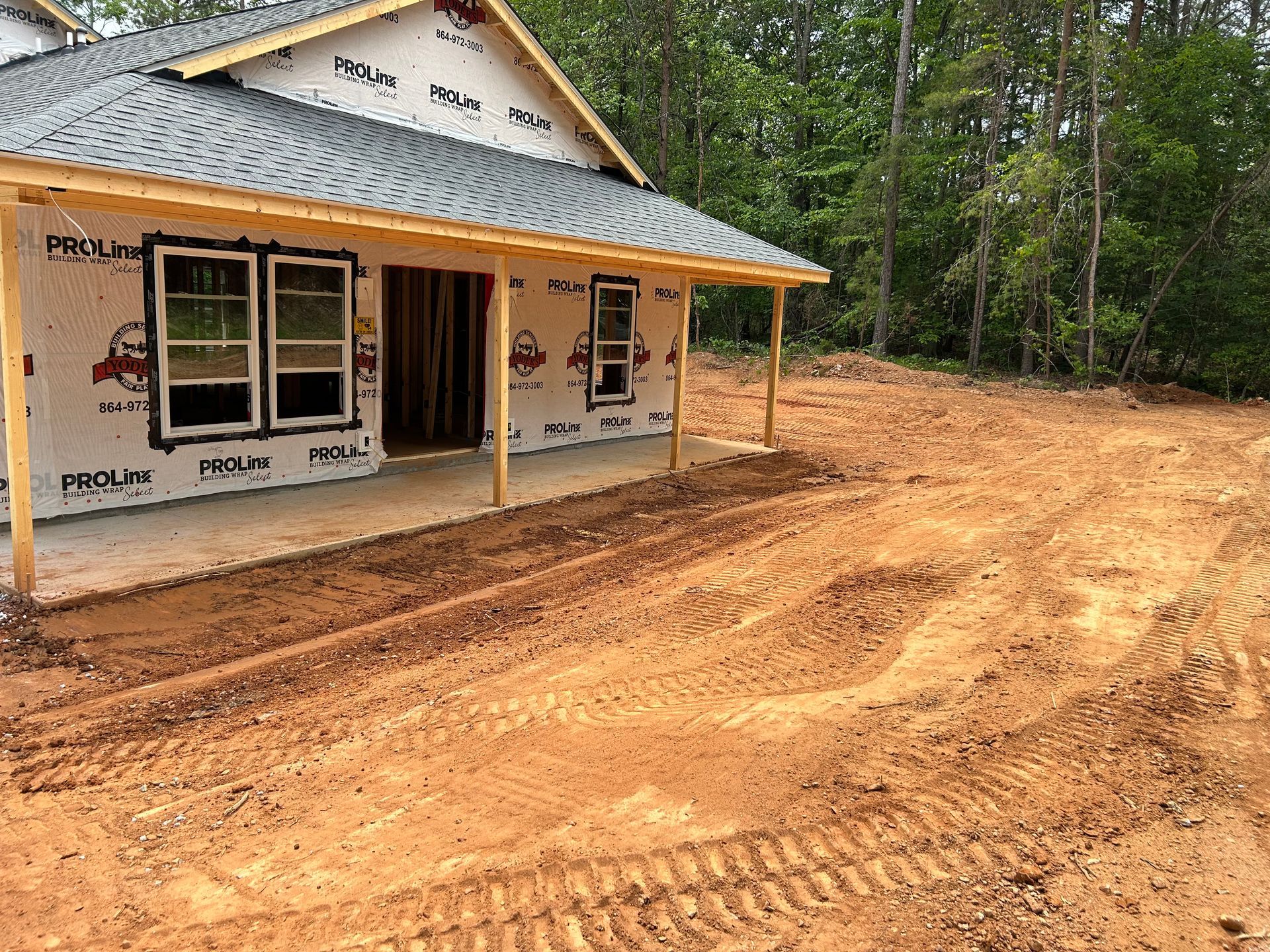 Yellow bulldozer grading dirt in a dusty, outdoor construction area.