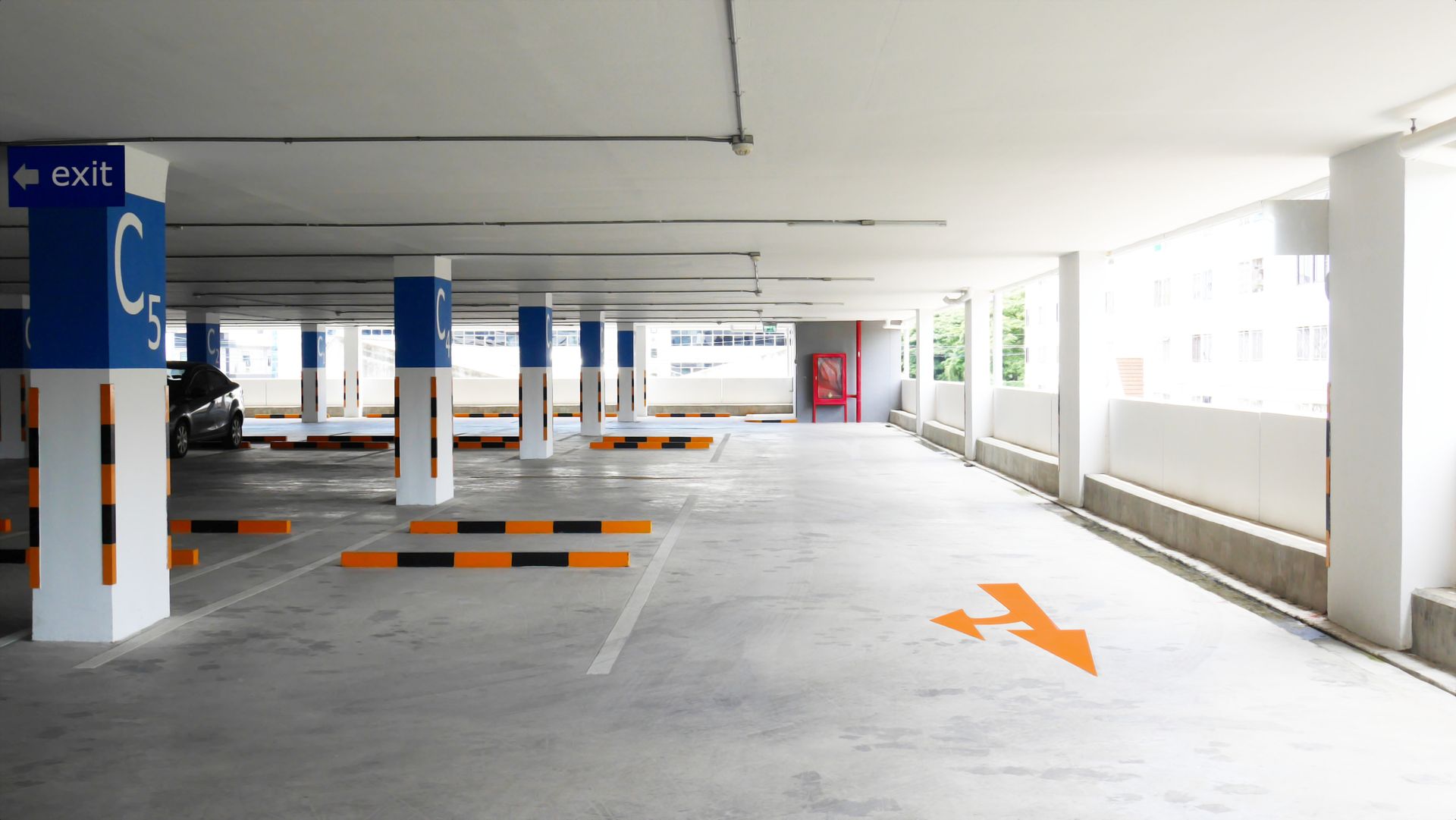 An empty parking garage with a sign that says exit on it.