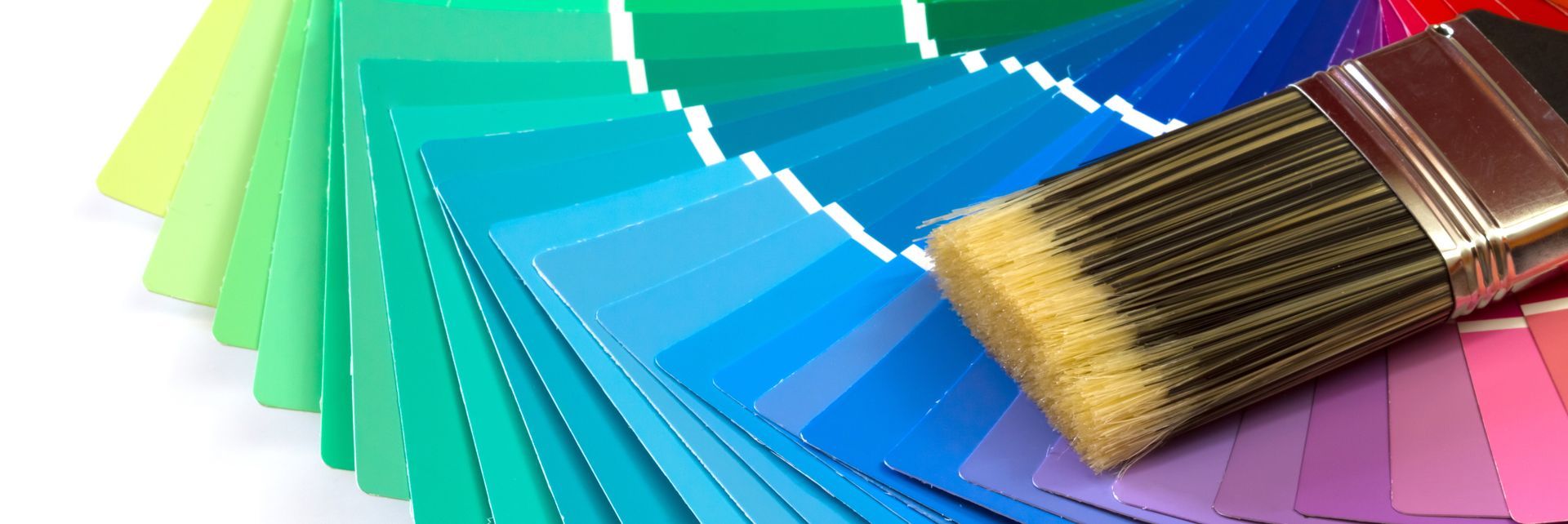 A paint brush is sitting on top of a color wheel.
