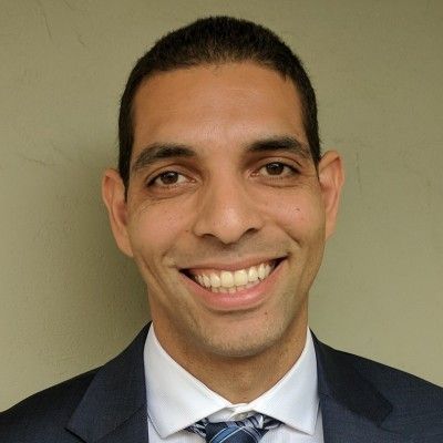 A man in a suit and tie is smiling for the camera.