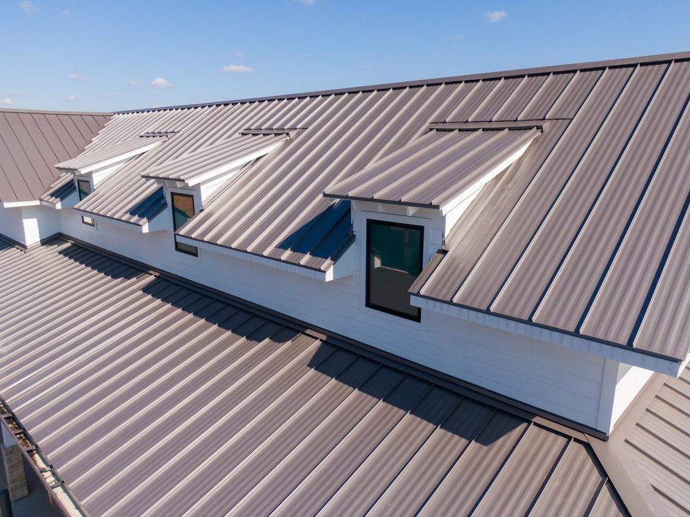 Metal rooftop with several skylights and vents on a sloped commercial building