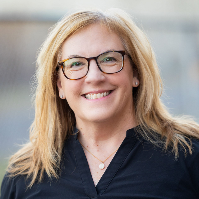 Jill Mahoney, Community Liaison, smiles outdoors, wearing a black top