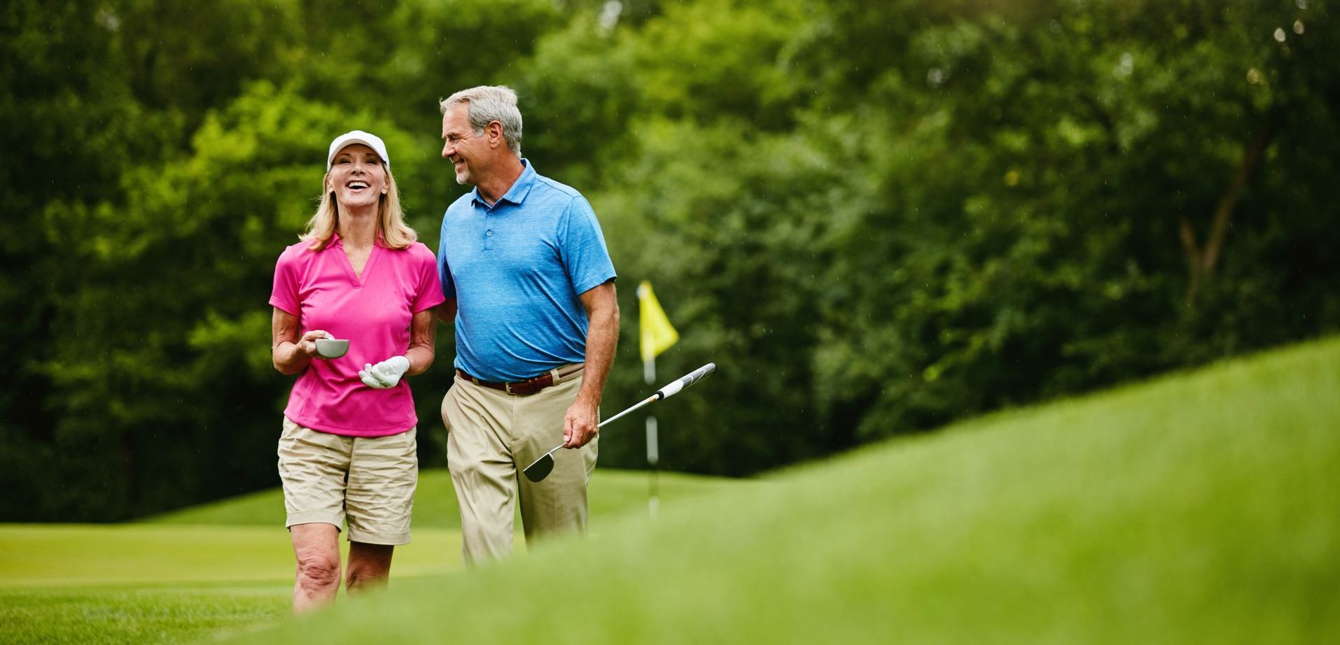 Mature couple walking on golf course, married couple golfing, retired couple laughing, homes near golf course, castlerock communities, castle rock homes, master planned communities, new homebuilder, new home builder, award winning home builder, when to buy a house, how to buy a house, buy or build a house