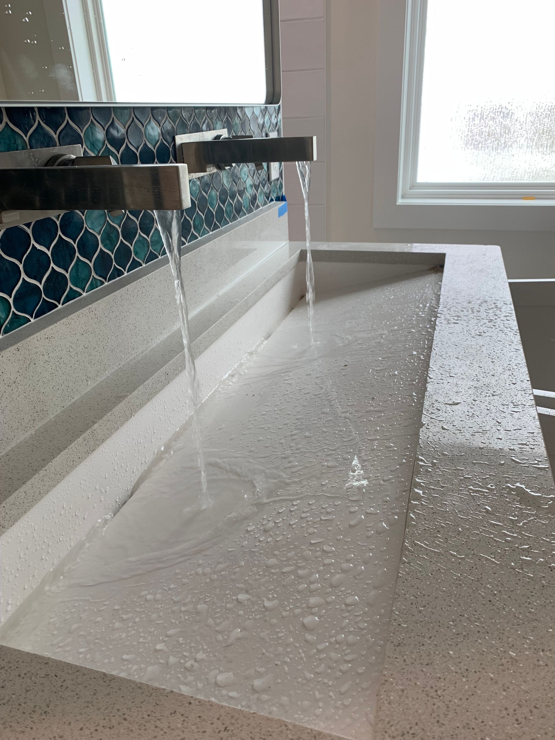 A person is fixing a sink pipe with a wrench.