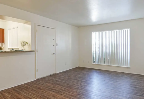 Empty room with dark wood-look flooring, white walls, door, and a window with vertical blinds. Ready to make Southgate Apartment Homes in Odessa, TX your home? Contact us today for more information about our pet-friendly 1, 2, and 3-bedroom apartment homes. Our community offers all the comfort and conveniences you’ll need and a prime location. We can’t wait to welcome you home!