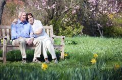 Elderly Couple Hugging On Bench