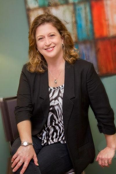 A woman in a black jacket is sitting in a chair