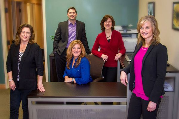 A group of people are posing for a picture in an office.