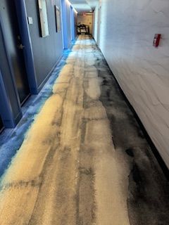 A long hallway in a hotel with a carpet on the floor.