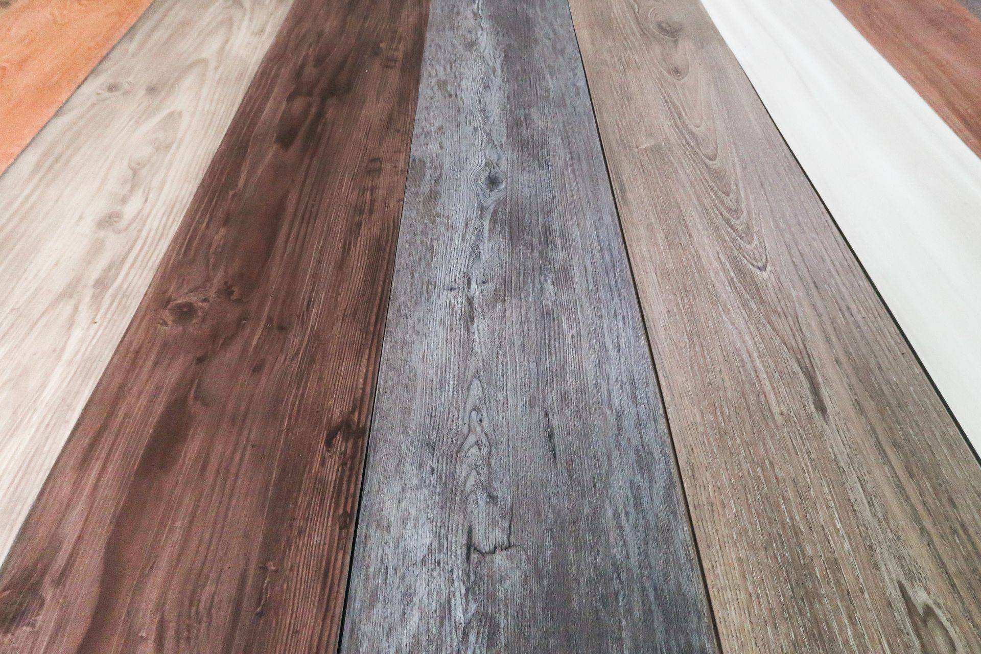 A row of different colored wooden floors are lined up on a table.