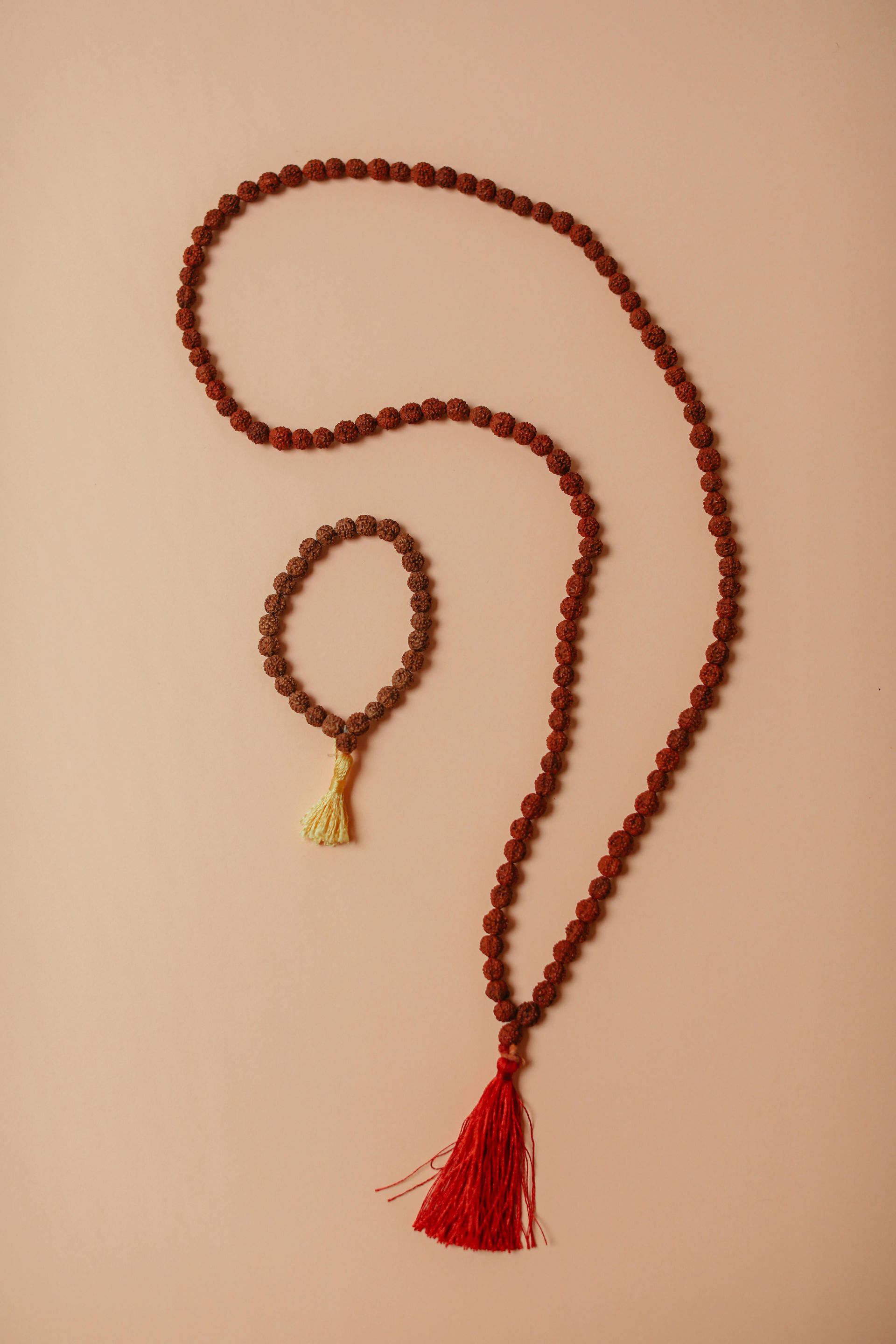 A necklace and bracelet with a red tassel