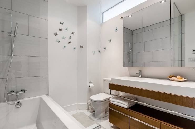 Une salle de bain avec baignoire , WC , lavabo et miroir.