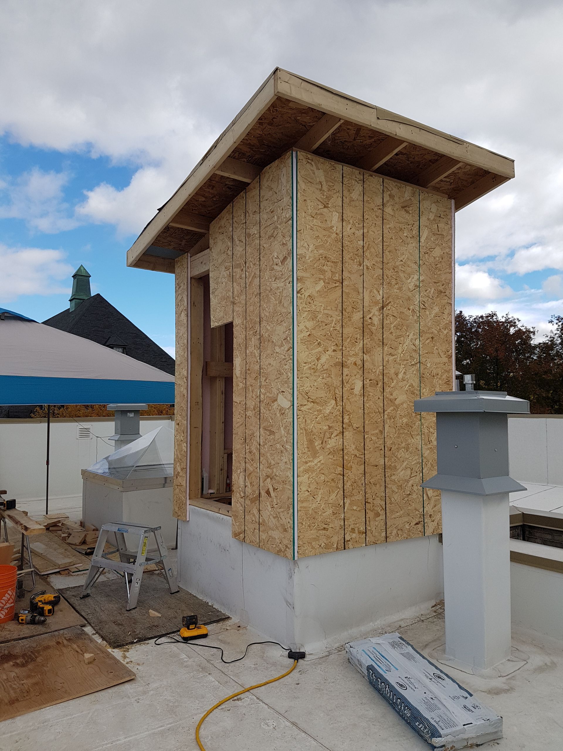 Une petite structure en bois est en cours de construction sur le toit d'un immeuble