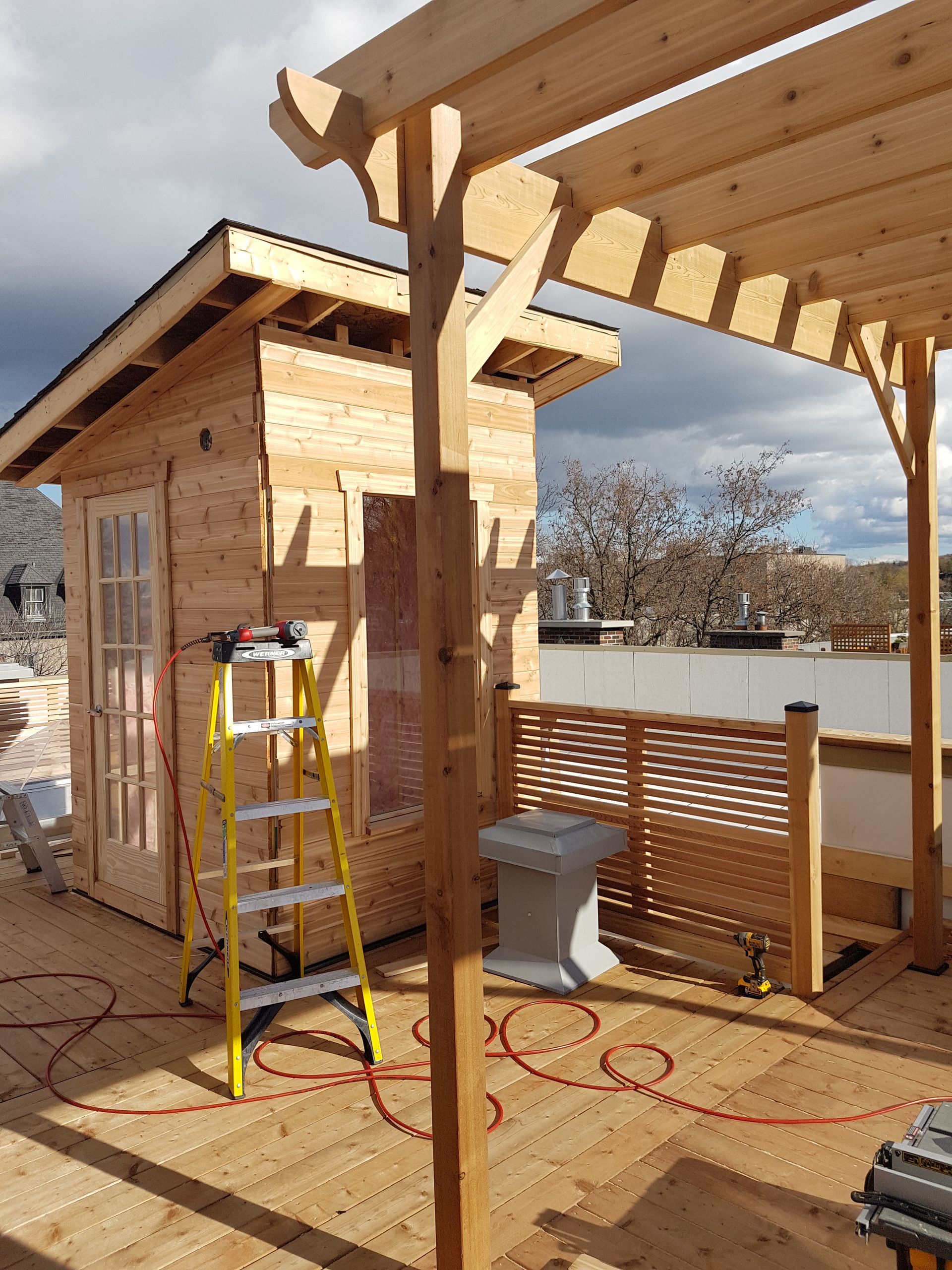 Une échelle est posée devant un bâtiment en bois en construction.