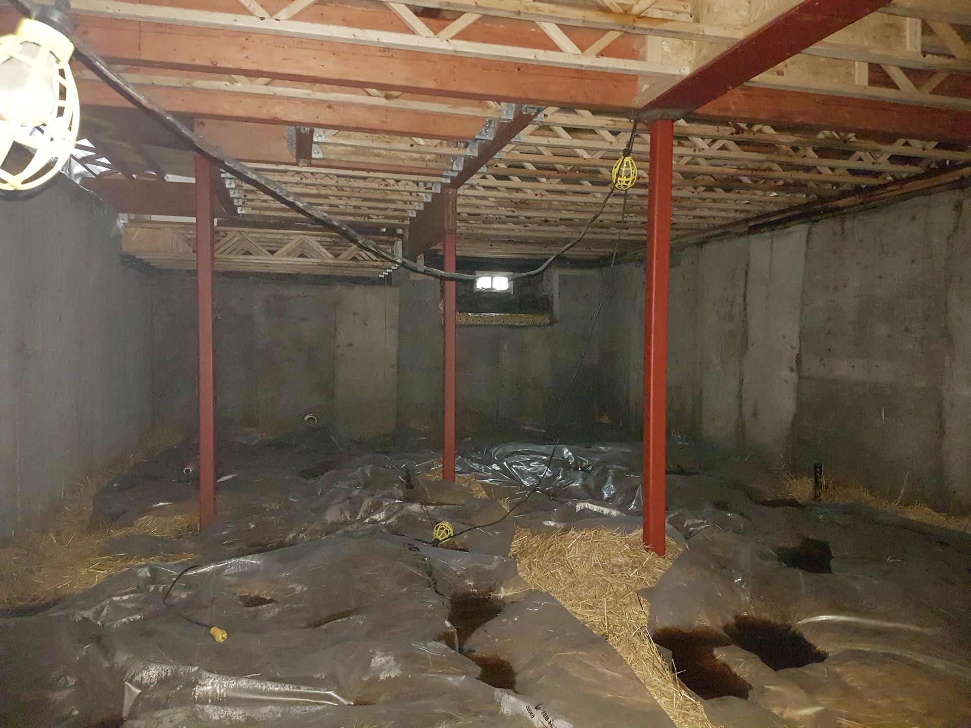 Un sous-sol vide avec un ventilateur de plafond suspendu au plafond.