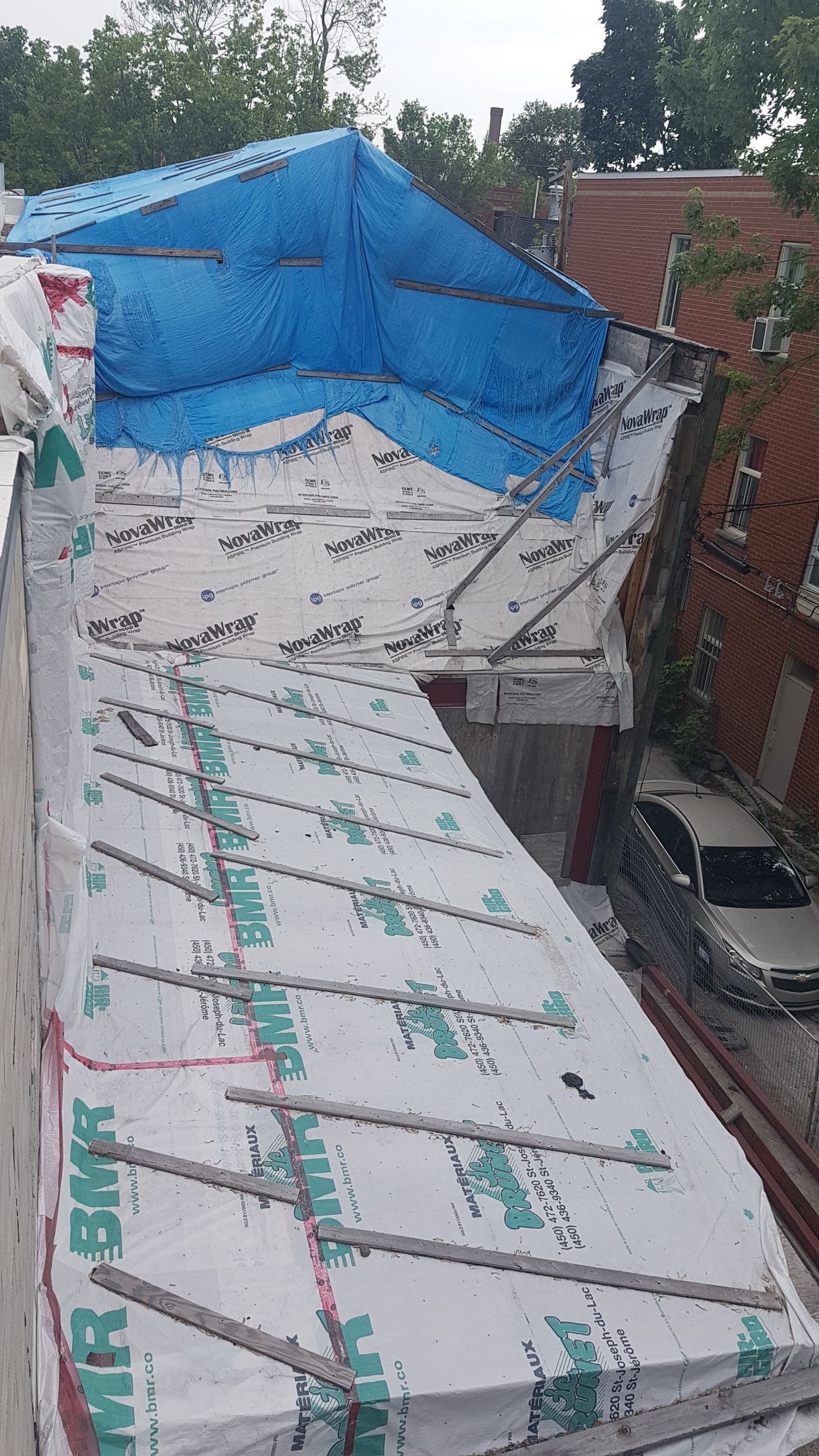 Une bâche bleue recouvre le toit d'un immeuble.