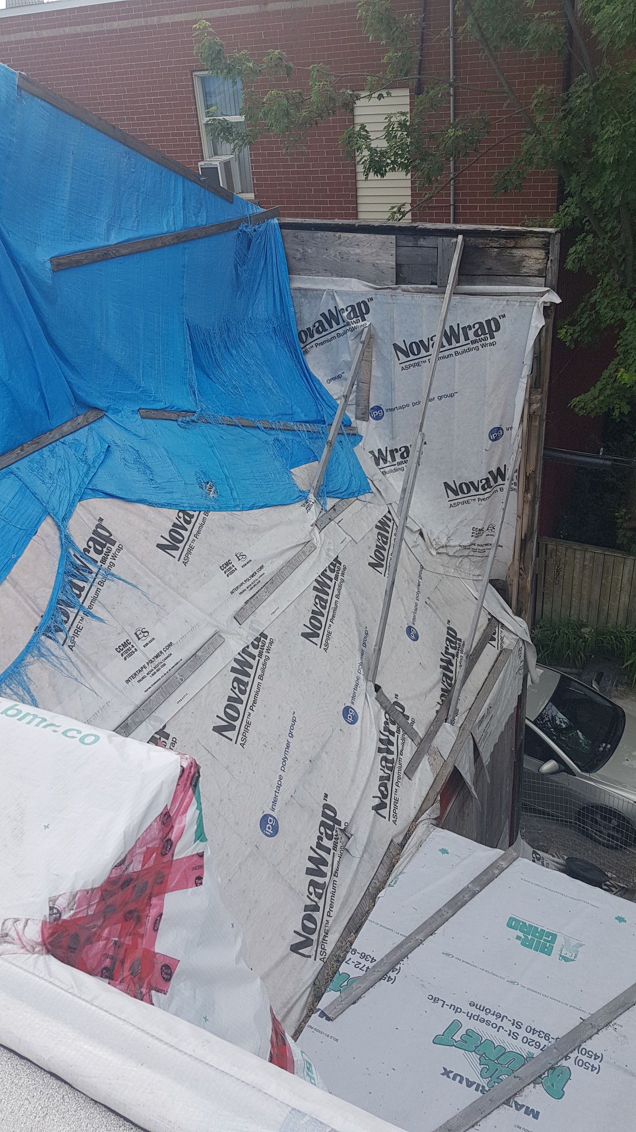 Une bâche bleue recouvre le toit d'un immeuble.