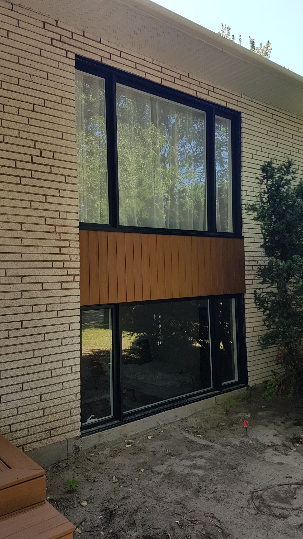 Une grande fenêtre sur le côté d'un bâtiment en brique.