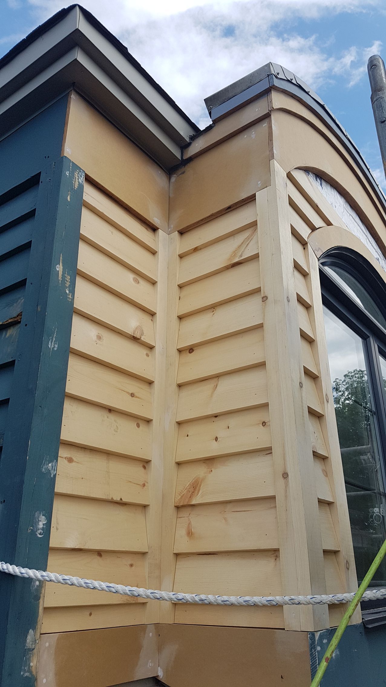 Un gros plan d'un bâtiment avec une corde autour et un ciel bleu en arrière-plan.