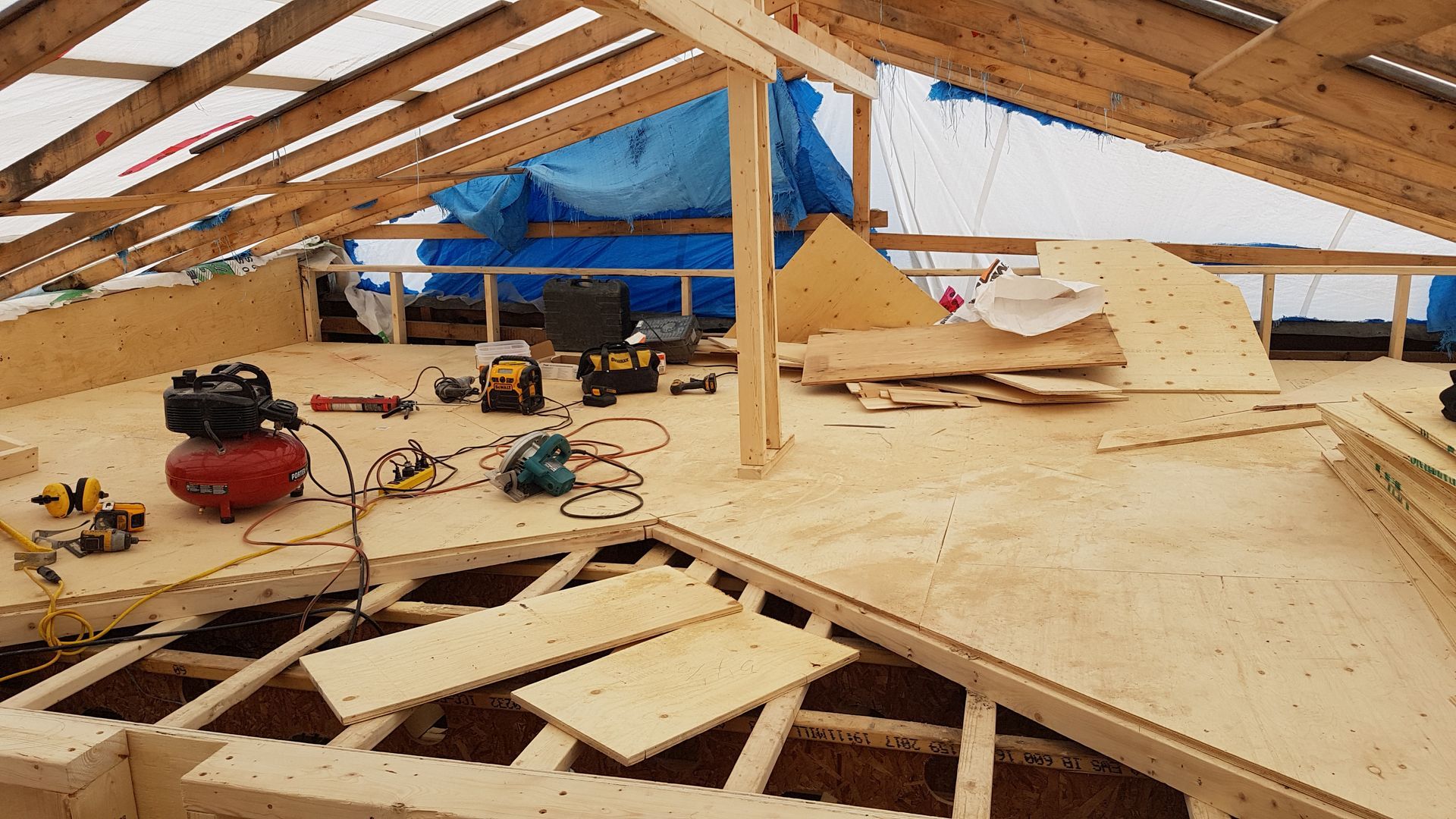 Un plancher en bois est en cours de construction sous un toit.