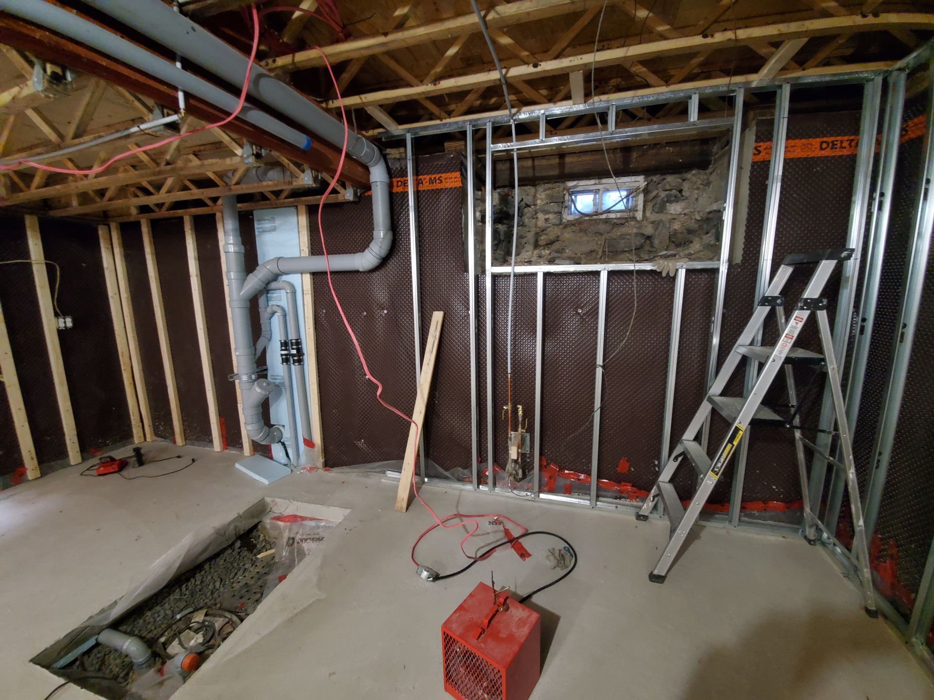Une échelle est posée au milieu d'une pièce en construction.