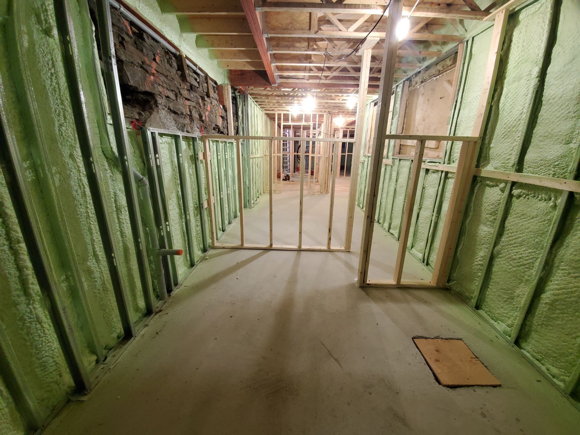 Un couloir avec des murs végétaux et une charpente en bois.