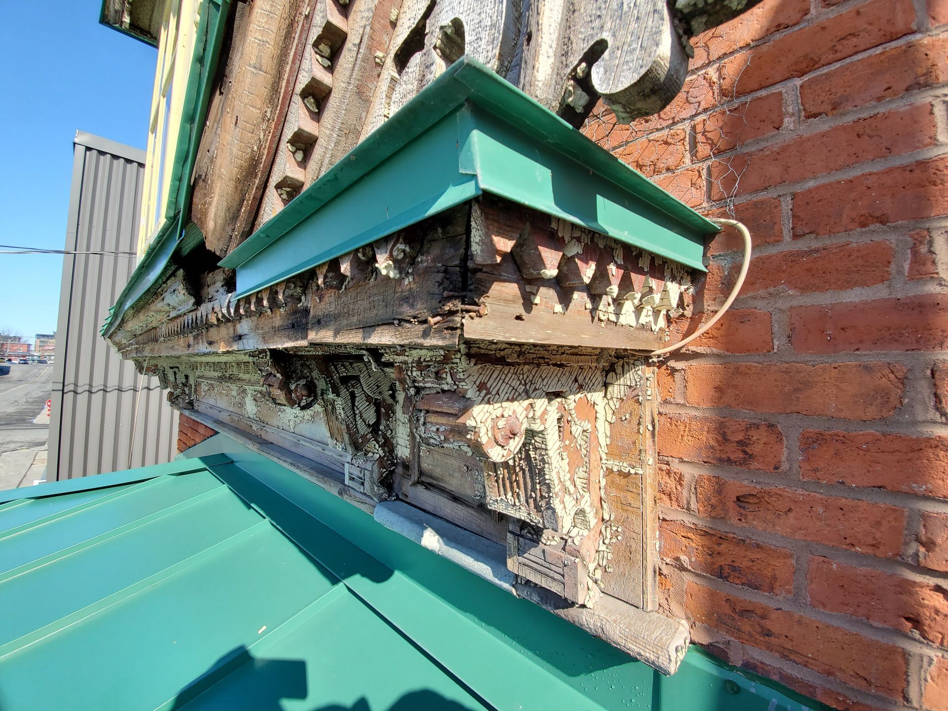 Un toit vert se trouve au sommet d'un bâtiment en brique.