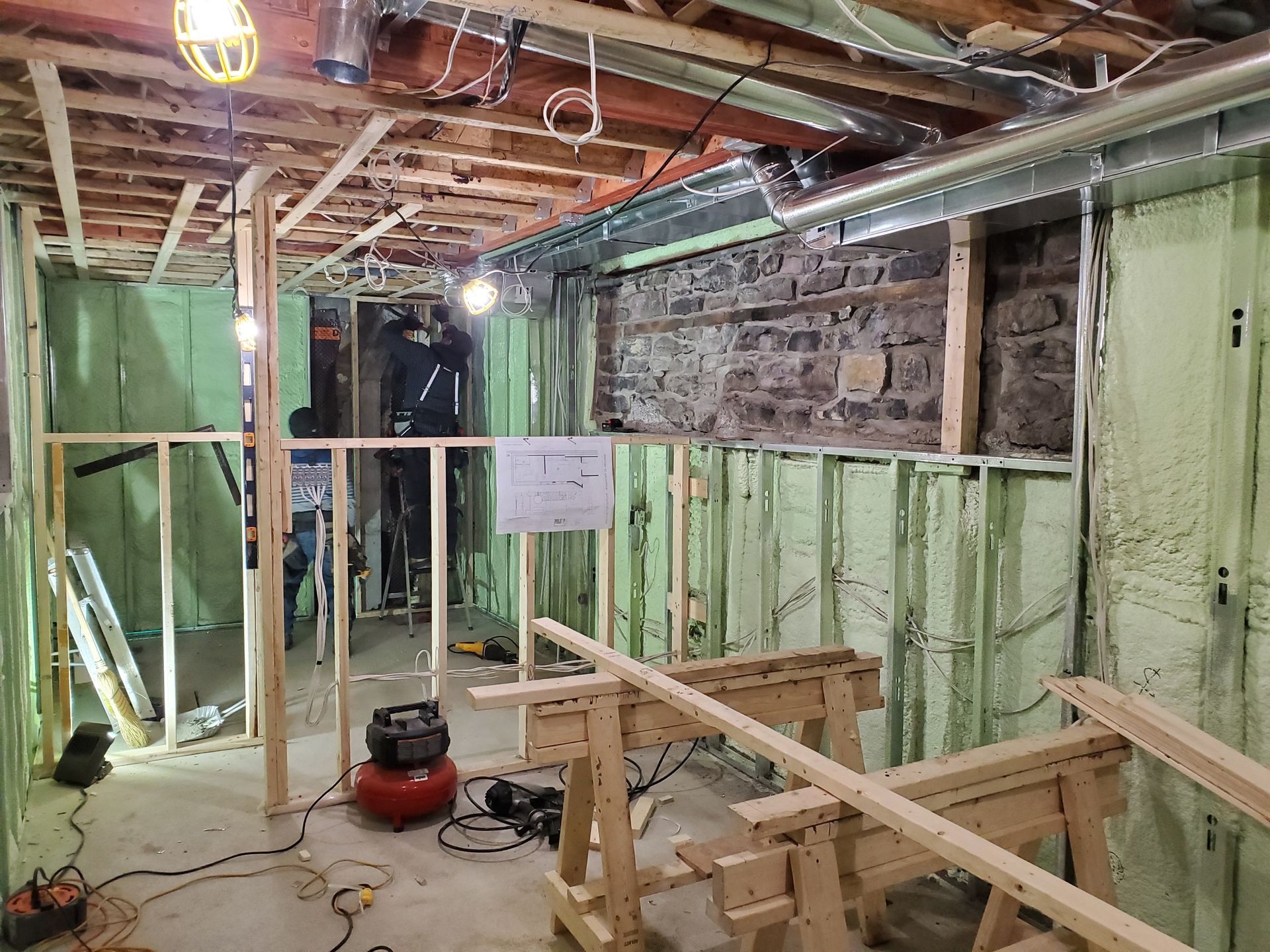 Un sous sol en cours de construction avec poutres en bois et un aspirateur.