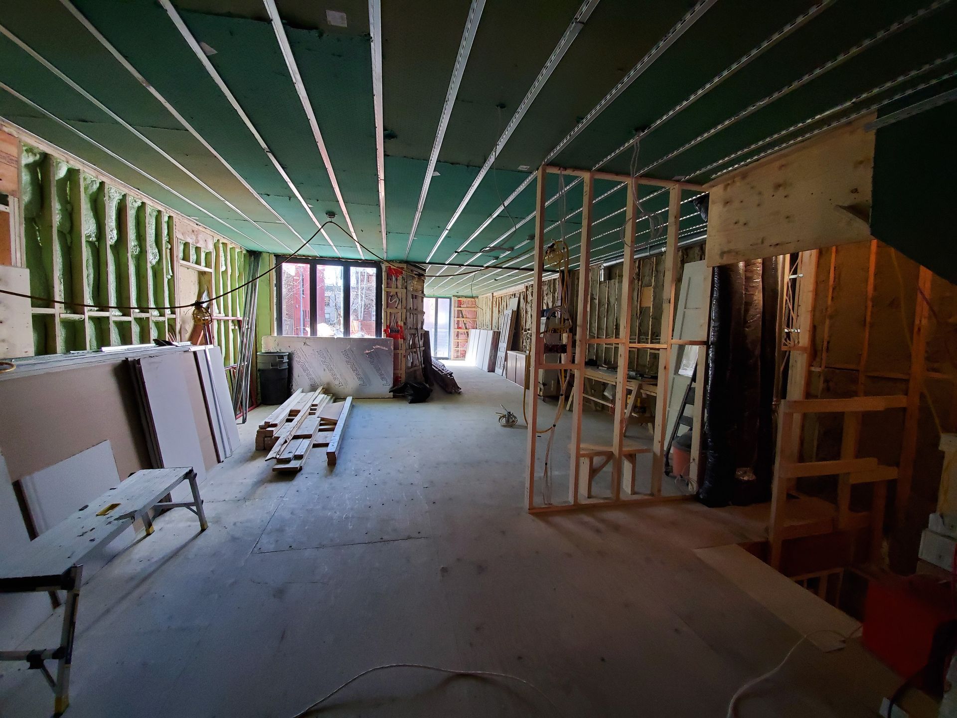 Une grande pièce avec un plafond vert est en cours de construction.