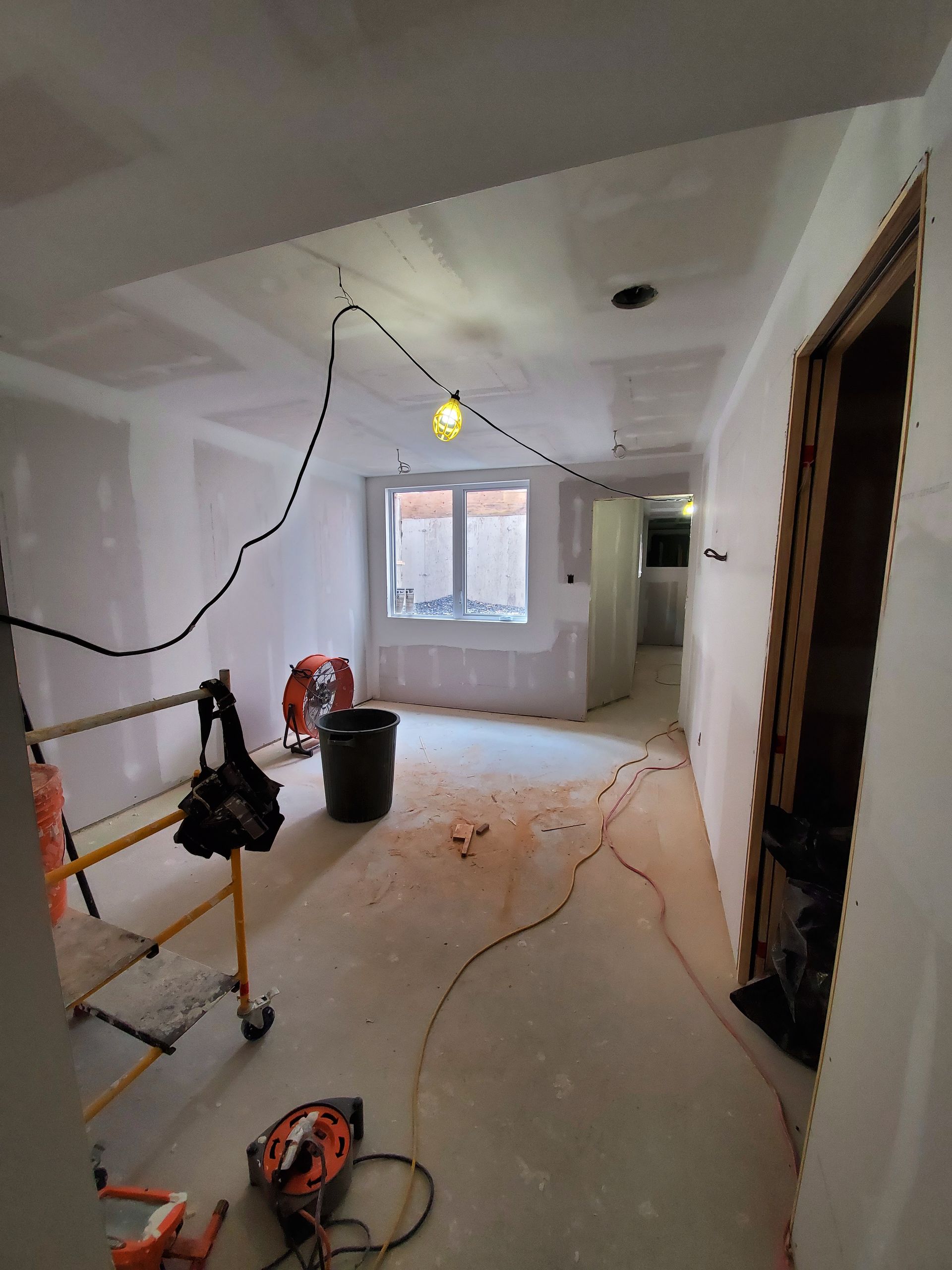 Une pièce en cours de rénovation avec beaucoup de fils suspendus au plafond.
