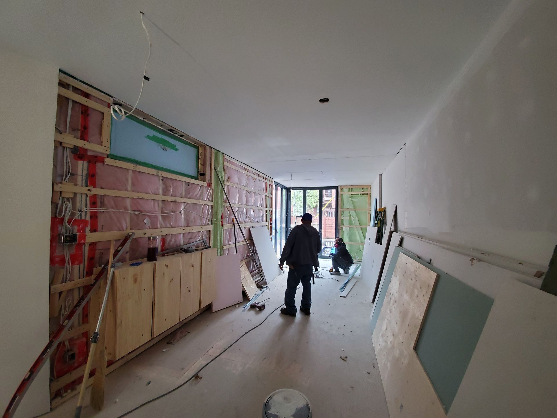 Un homme se tient dans une pièce en cours de rénovation.
