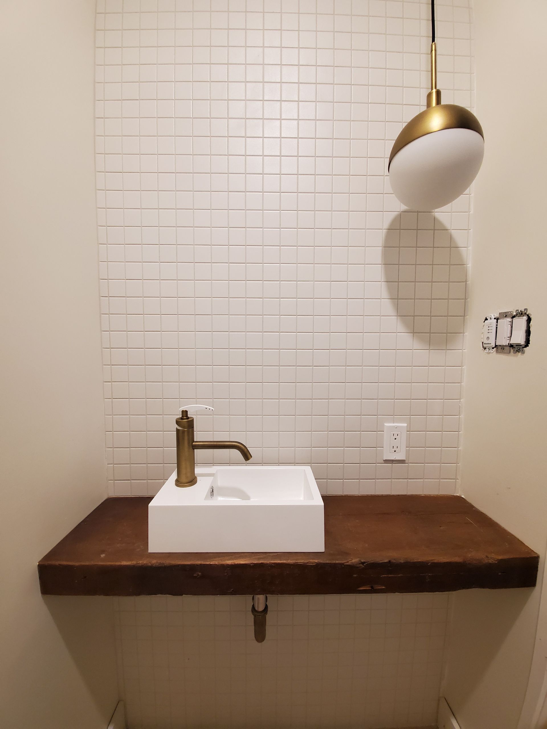 Une salle de bain avec un lavabo et un comptoir en bois.