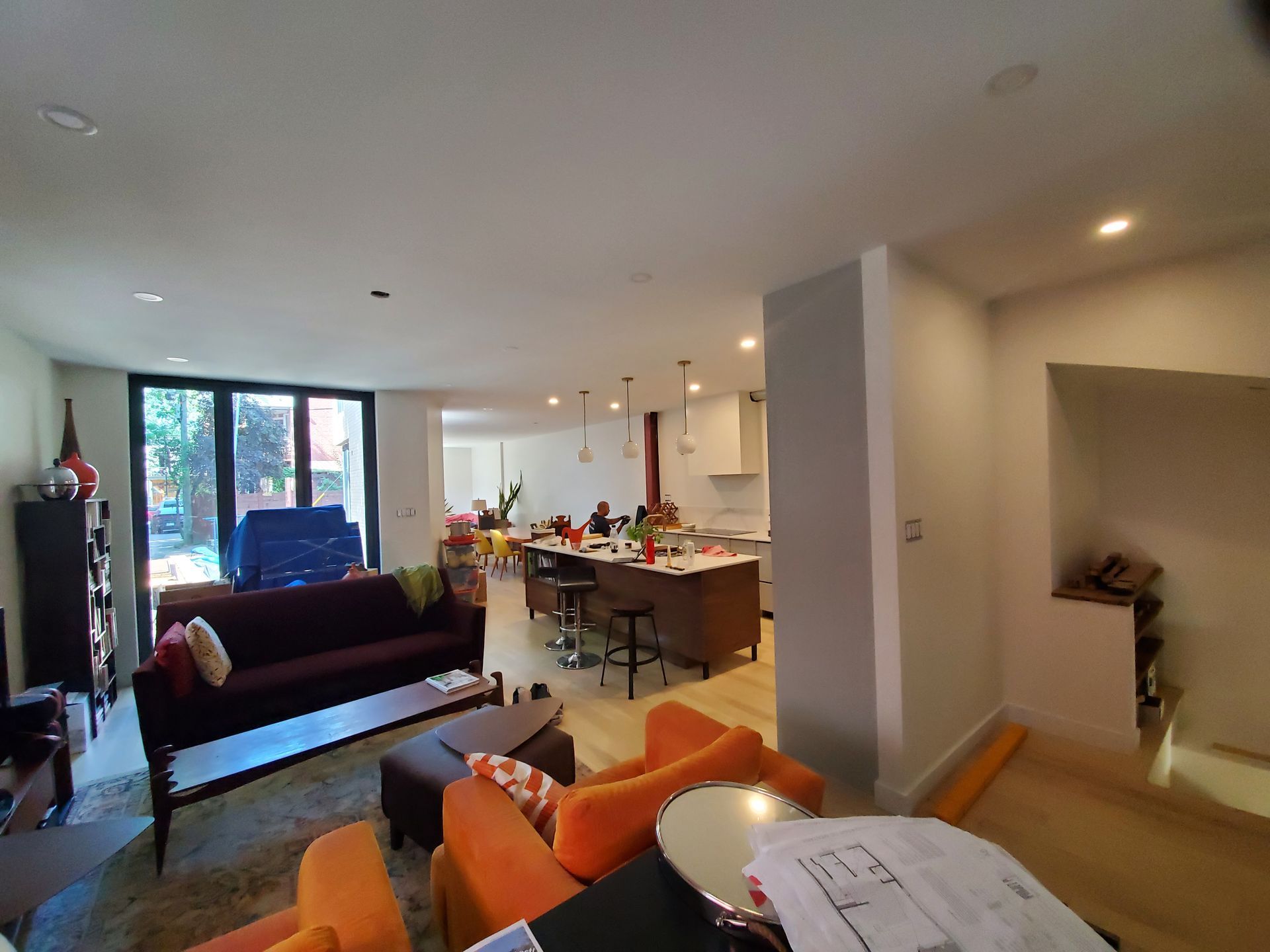Un salon avec un canapé, des chaises, des poufs et une table.