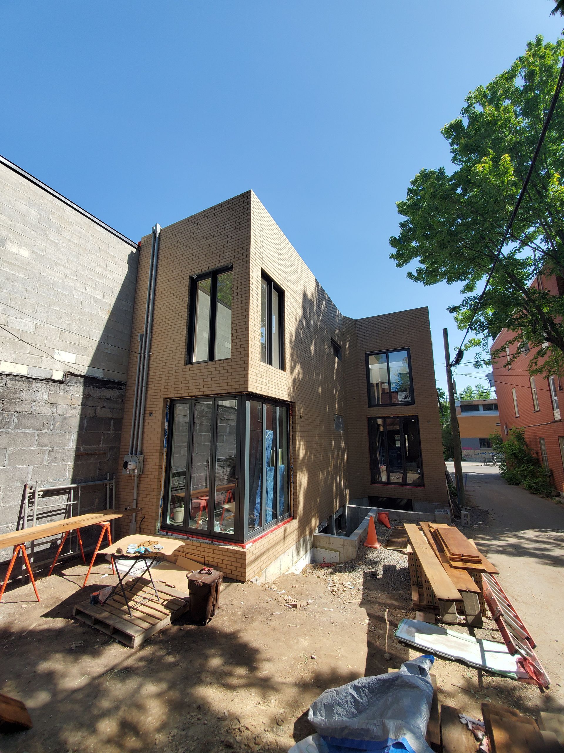 Un grand bâtiment en brique avec de nombreuses fenêtres est en construction.