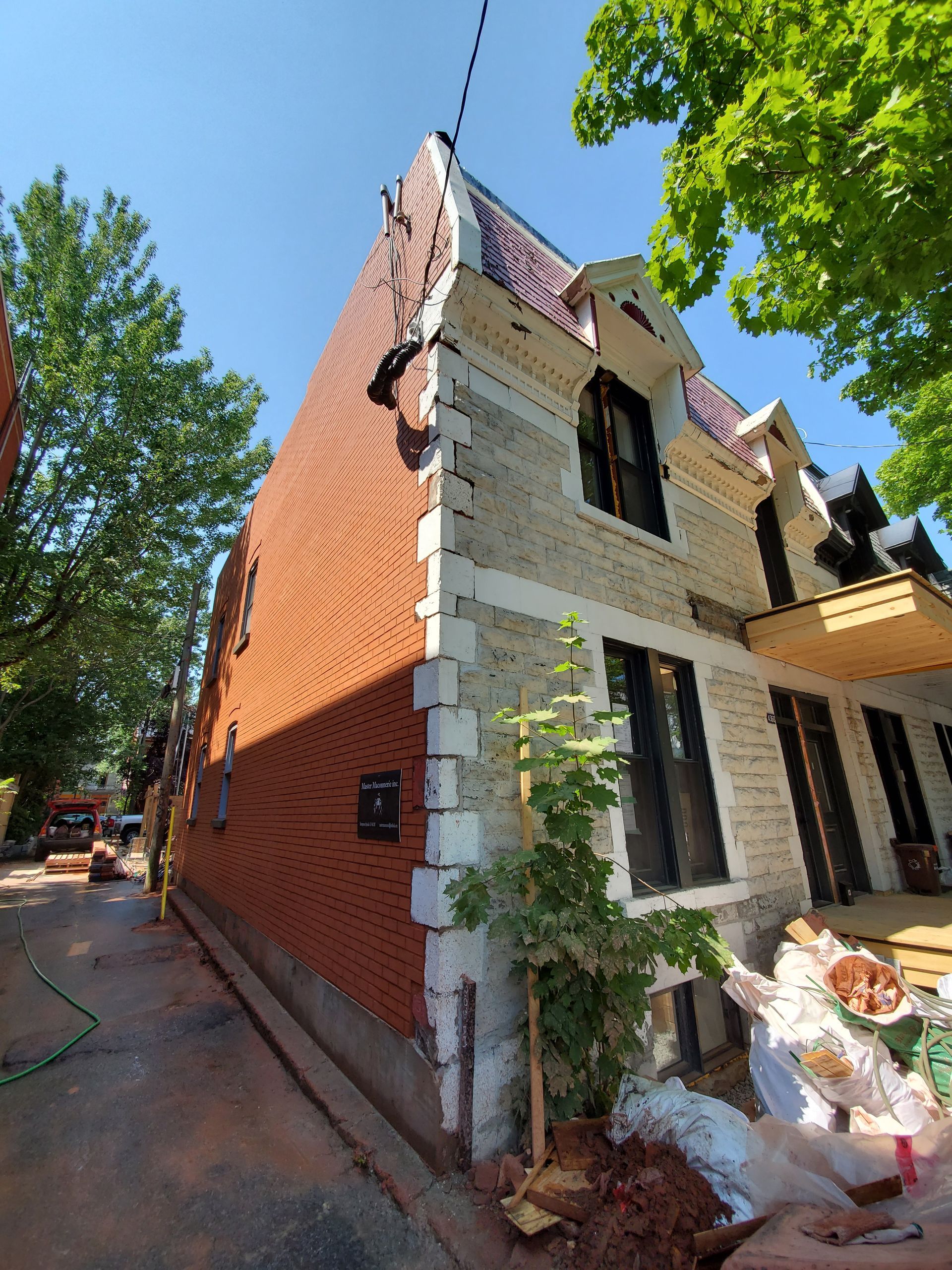 Une grande maison en brique est en cours de rénovation dans une ville.