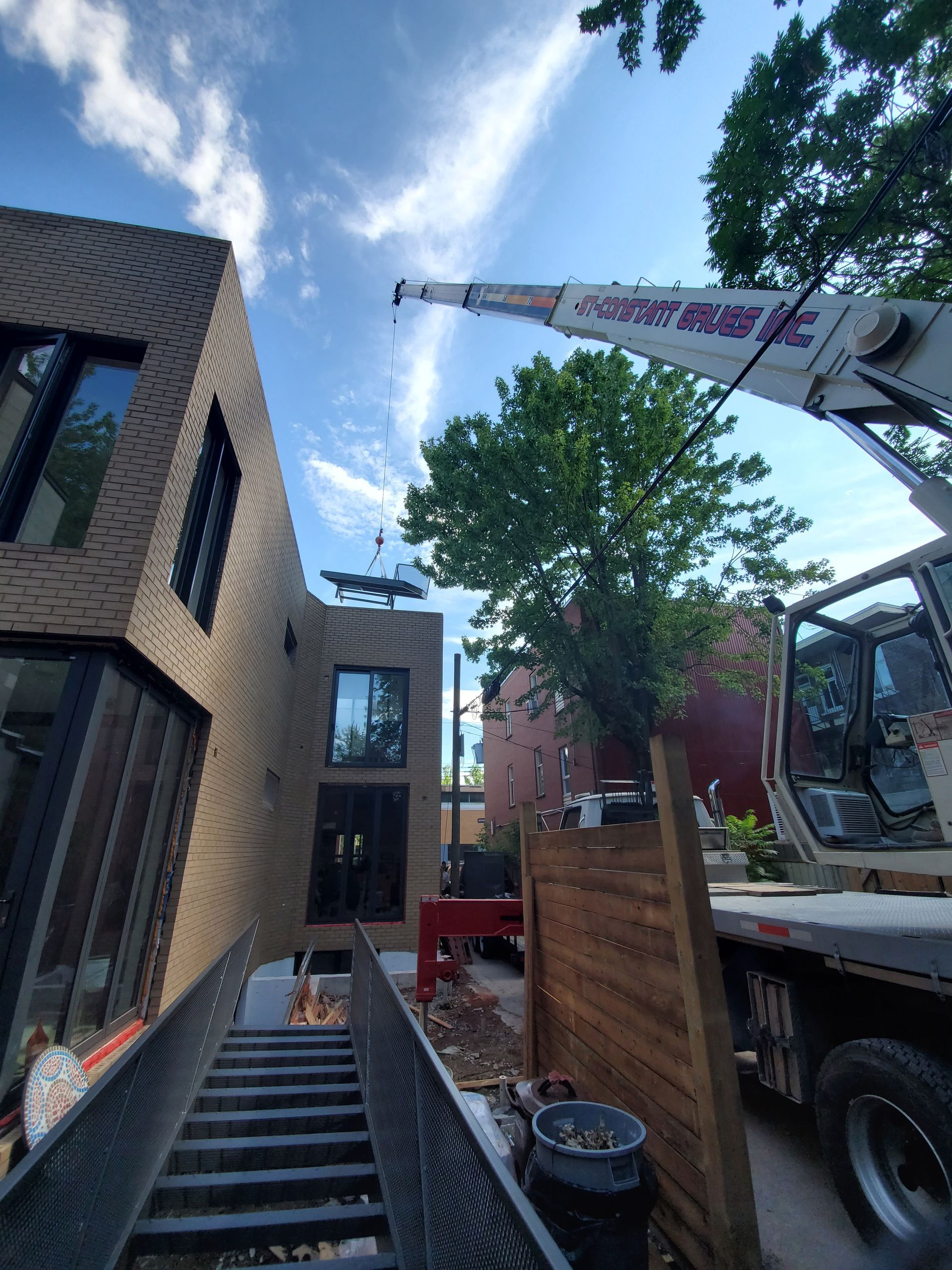Une grue est utilisée pour retirer un arbre d'un bâtiment