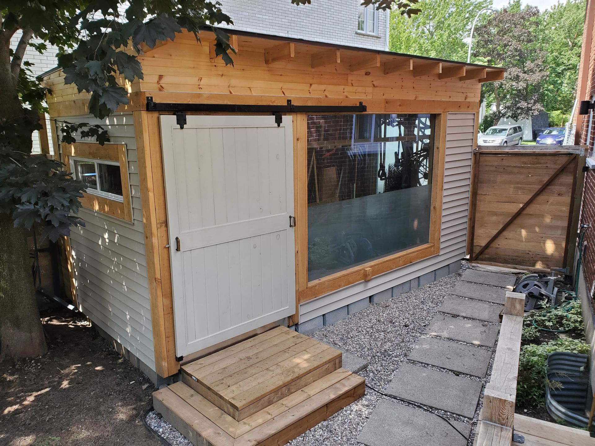 Un petit cabanon en bois avec une porte coulissante en verre