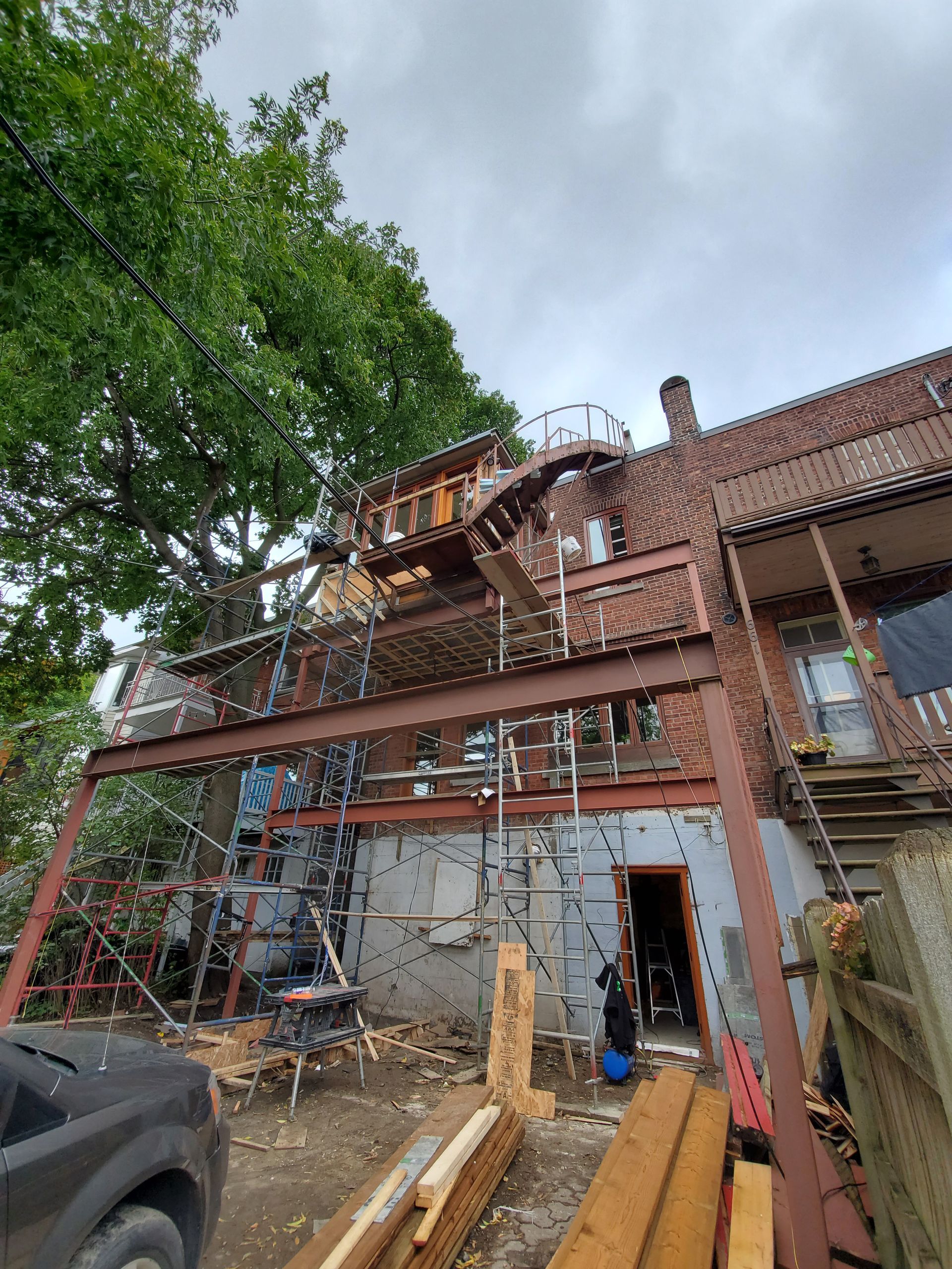 Une maison est en cours de rénovation avec une terrasse et des escaliers.