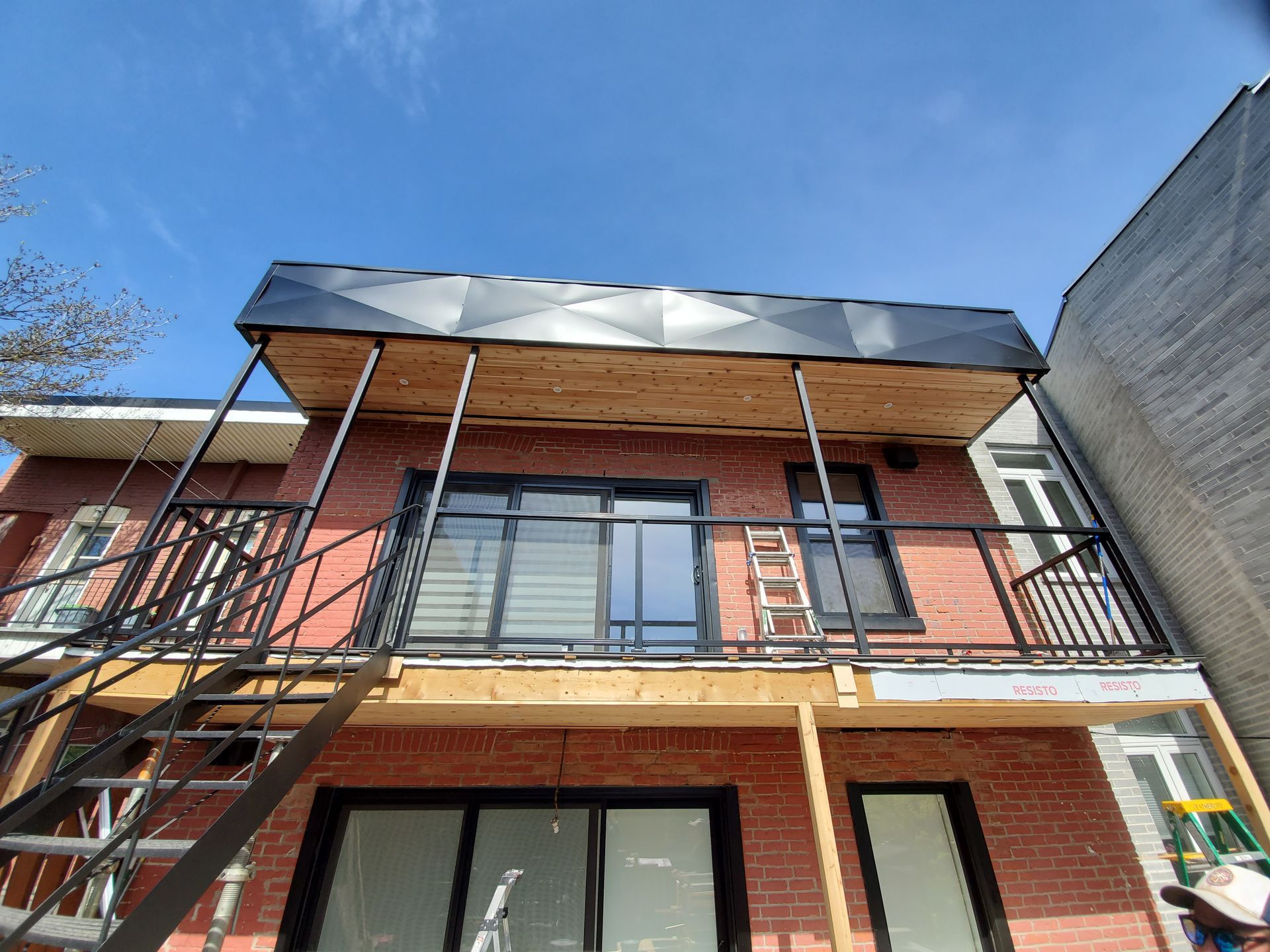 Un bâtiment en brique avec balcon et escaliers en construction.